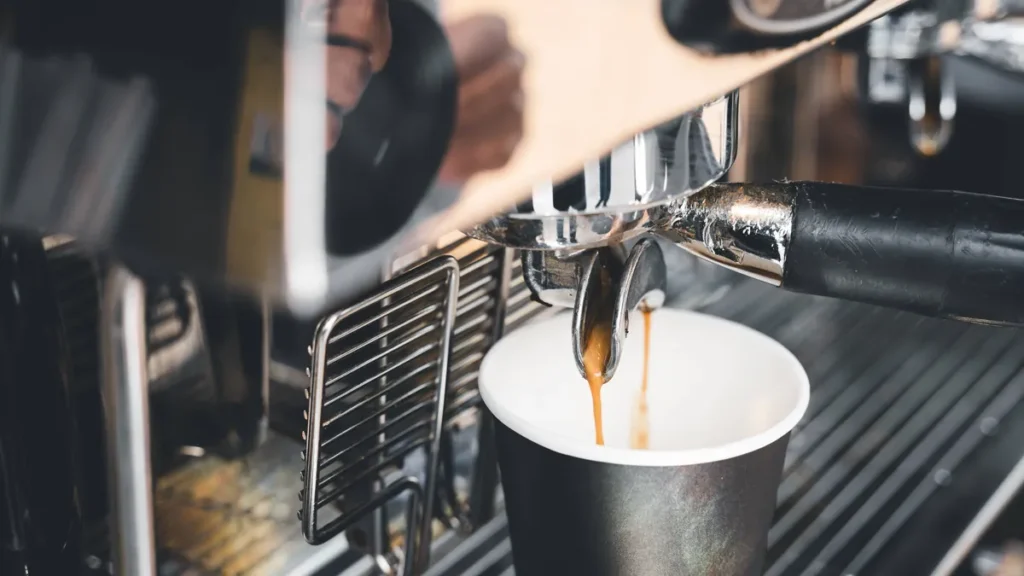 17-july-2023-freshly-brewed-coffee-flows-from-a-portafilter-coffee-machine-into-a-to-go-cup-frisch-g.webp
