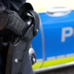 polizist-vor-einem-einsatzwagen-symbolbild-bei-einer-aktion-in-zwoelf-bundeslaendern-ist-die-polizei.webp