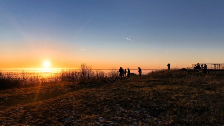 Besucher-geniessen-die-letzten-Sonnenstrahlen-auf-einem-Berggipfel-im-Weserbergland.jpg