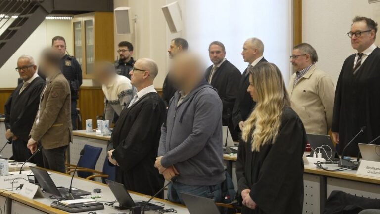 Die-Angeklagten-und-ihre-Anwaelte-stehen-auf-als-das-Gericht-den-Saal-betritt-Nach-fast-zwei-Jahren.jpeg