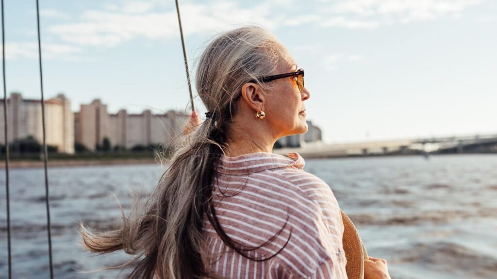 Side-view-of-mature-woman-wearing-sunglasses-and-looking-to-the-distance-while-standing-on-the-yacht.jpeg
