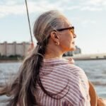 Side-view-of-mature-woman-wearing-sunglasses-and-looking-to-the-distance-while-standing-on-the-yacht.jpeg