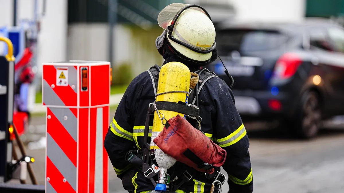 ein-feuerwehrmann-mit-atemschutzgeraet-symbolbild-ein-mensch-ist-bei-einem-brand-in-hamburg-hausbruc.webp