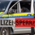 ein-polizeiauto-hinter-einem-absperrband-symbolbild.jpg