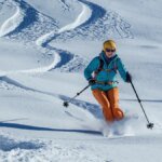 kitzbuehel-eine-skifahrerin-wedelt-bei-sonnenschein-eine-piste-hinunter.jpg