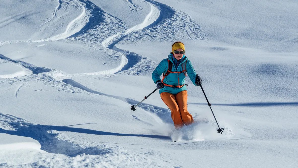 kitzbuehel-eine-skifahrerin-wedelt-bei-sonnenschein-eine-piste-hinunter.jpg