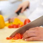 koch-schneidet-tomaten-auf-weissem-brett-rotes-gemuese-hinterlaesst-oft-rote-oder-gelbe-flecken-auf.webp