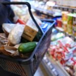 1768180025_Eine-Kundin-geht-mit-einem-Einkaufskorb-und-ihrem-Einkauf-an-den-Regalen-in-einem-Supermarkt-vorbei.jpeg