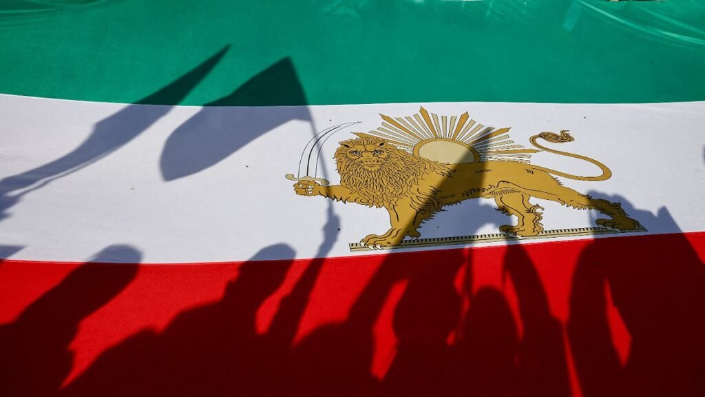 Demonstrators-cast-shadows-on-a-Lion-and-Sun-pre-Iranian-Revolution-national-flag-during-a-rally-in.jpeg