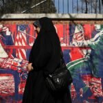 TEHRAN-IRAN-JANUARY-28-A-woman-walks-past-an-anti-American-murals-following-a-possible-US-interventi.jpeg