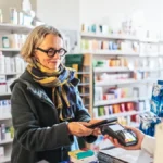 eine-kundin-zahlt-in-der-apotheke-symbolbild-wer-sich-von-zuzahlungen-fuer-medizinische-leistungen-b.webp