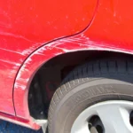kratzer-an-einem-roten-auto-symbolbild-protokollieren-sie-bestehende-schaeden-am-auto-bevor-sie-den.webp