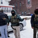 An-Immigration-and-Customs-Enforcement-ICE-agent-gestures-during-an-immigration-raid-days-after-an-I.jpeg