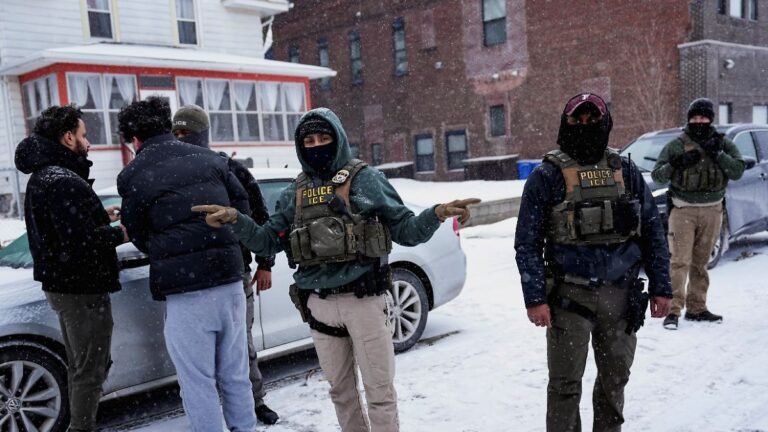 An-Immigration-and-Customs-Enforcement-ICE-agent-gestures-during-an-immigration-raid-days-after-an-I.jpeg