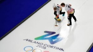 Germany-s-Felix-Messenzehl-and-Johannes-Scheuerl-sweep-ahead-of-a-stone-during-a-men-s-curling-round.jpeg