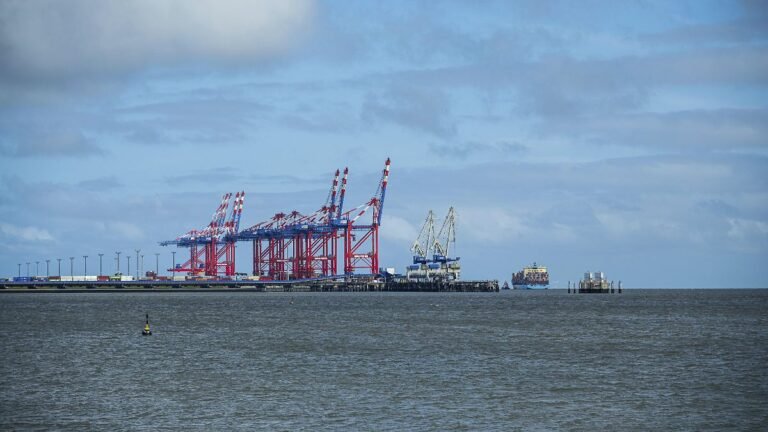 Industriehafen-mit-markanten-roten-Kranen-unter-teilweise-bewoelktem-Himmel-JadeWeserPort-Wilhelmsha.jpeg