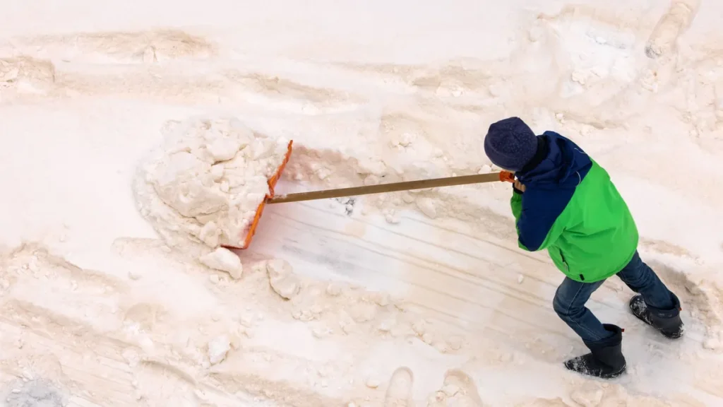 blutschnee-mit-sandstaub-aus-der-sahara-ein-kind-schiebt-mit-einem-schneeschieber-eine-spur-in-den-i.webp