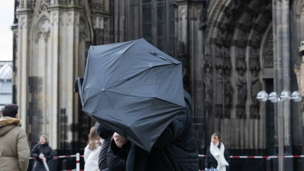 einem-mann-weht-vor-dem-koelner-dom-ein-regenschirm-ins-gesicht-archivbild-in-den-kommenden-tagen-wi.webp