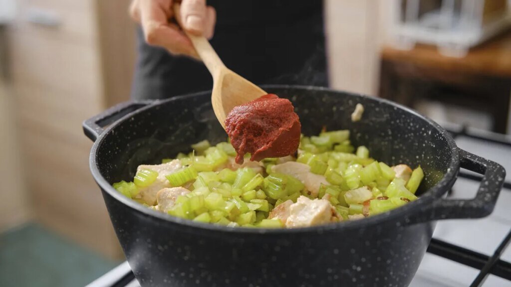mann-gibt-tomatenmark-beim-kochen-hinzu-symbolbild-ein-unternehmen-warnt-vor-glasssplittern.jpg