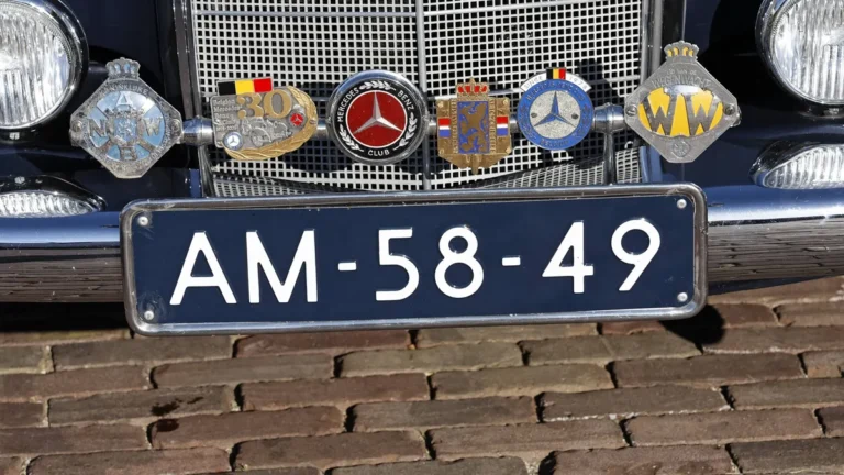 plaketten-von-automobilclubs-auf-der-stossstange-eines-mercedes-hollaendisches-nummernschild-niederl.webp