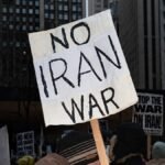 A-protester-holds-placards-reading-No-Iran-war-during-a-demonstration-against-the-war-in-Iran-in-Chi.jpeg