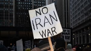 A-protester-holds-placards-reading-No-Iran-war-during-a-demonstration-against-the-war-in-Iran-in-Chi.jpeg