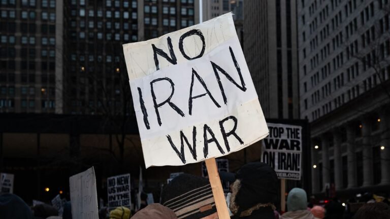 A-protester-holds-placards-reading-No-Iran-war-during-a-demonstration-against-the-war-in-Iran-in-Chi.jpeg