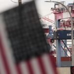 Eine-US-Flagge-haengt-im-Hafen-vor-Containern.jpg