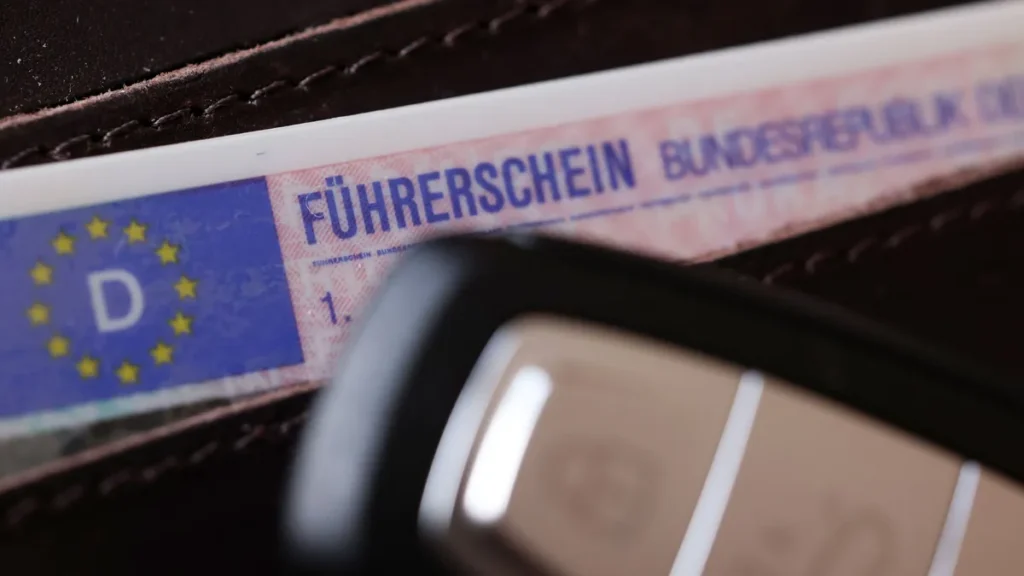 ein-fuehrerschein-fuehrerschein-der-bundesrepublik-deutschland-in-einem-portmonnaie-mit-einem-autosc.webp