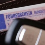 ein-fuehrerschein-fuehrerschein-der-bundesrepublik-deutschland-in-einem-portmonnaie-mit-einem-autosc.webp