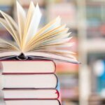 ein-offenes-buch-auf-einem-buecherstapel-stellen-sie-ihr-allgemeinwissen-unter-beweis.jpg
