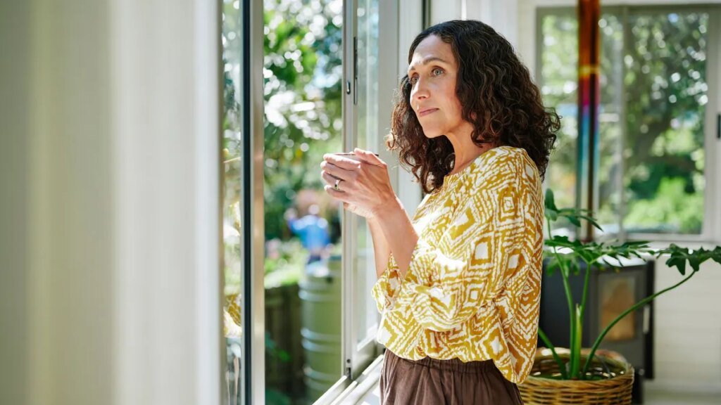 eine-frau-schaut-aus-dem-fenster-symbolbild-wer-allein-lebt-denkt-oft-nicht-an-ein-testament.jpg