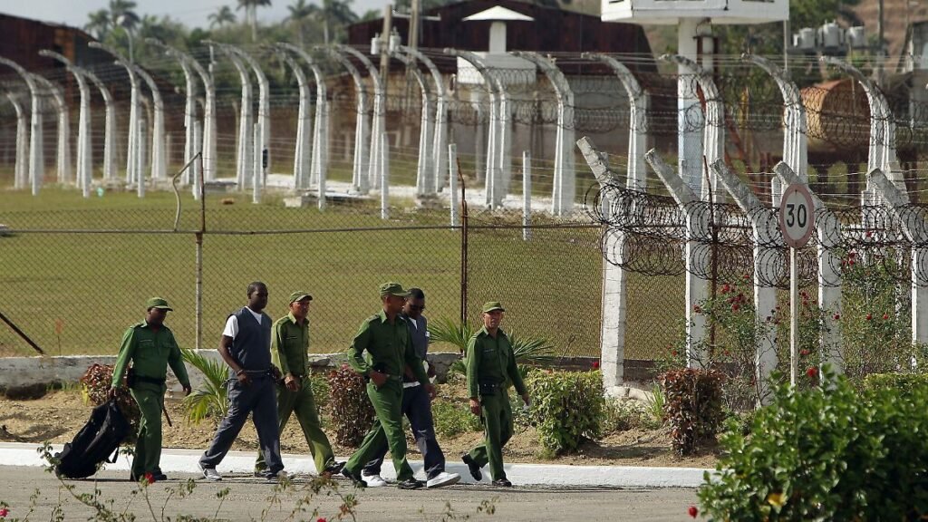 epa03655941-Several-soldiers-escort-two-inmates-at-prison-Combinado-del-Este-during-a-visit-of-natio.jpeg