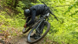 mountain-biker-adjusting-his-bike-in-scenic-pyrenees-a-man-in-protective-gear-adjusts-his-mountain-b.webp