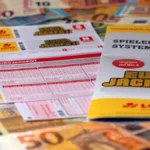 spielscheine-des-eurojackpots-zwischen-geldscheinen-symbolfoto-in-nordrhein-westfalen-hat-ein-unbeka.webp