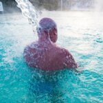 ein-kurgast-steht-unter-einem-wasserfall-in-einem-aussenbecken-der-europatherme-in-bad-fuessing.jpg