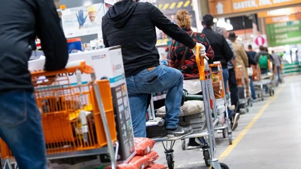 kunden-stehen-mit-einkaufswagen-in-einem-baumarkt-in-einer-schlange-vor-den-kassen-an.jpg