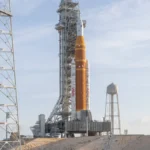 nasas-artemis-ii-space-launch-system-sls-rocket-and-orion-spacecraft-are-seen-standing-atop-a-mobile.webp