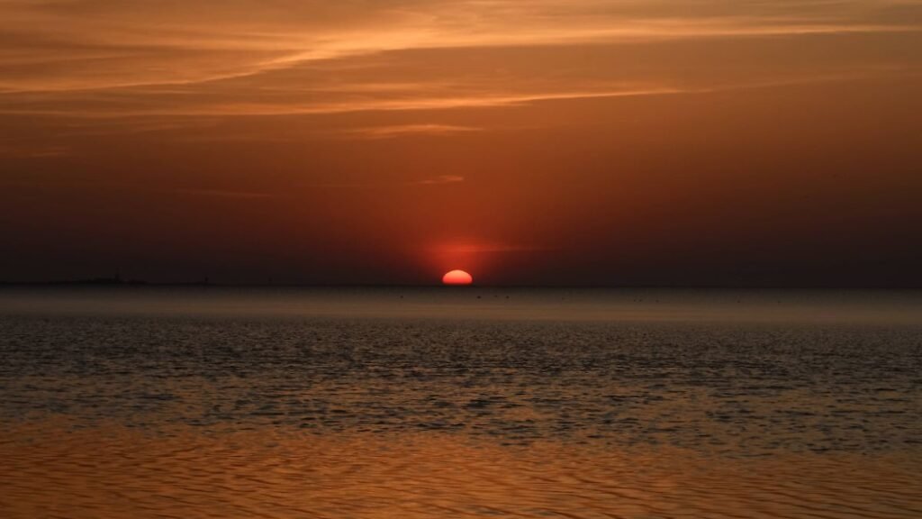 stimmungsvoller-Sonnenuntergang-Cuxhaven-Nordsee-bei-ruhigem-Wetter-glutrote-Sonne-versinkt-im-Meer.jpeg