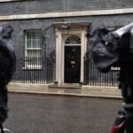 Cameras-are-covered-with-rain-covers-as-journalists-wait-for-a-showing-of-Britain-s-Prime-Minister-K.jpeg