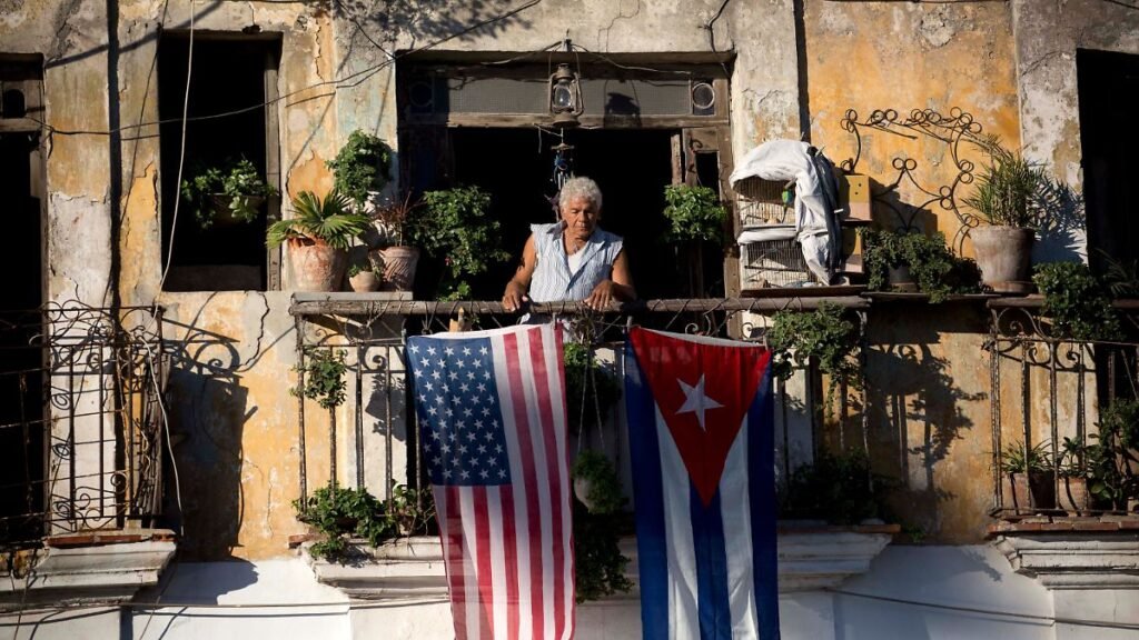 FILE-Javier-Yanez-stands-on-his-balcony-where-he-hung-a-U-S-and-Cuban-flag-in-Old-Havana-Cuba-Friday.jpeg