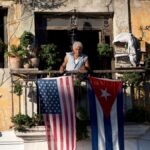 FILE-Javier-Yanez-stands-on-his-balcony-where-he-hung-a-U-S-and-Cuban-flag-in-Old-Havana-Cuba-Friday.jpeg
