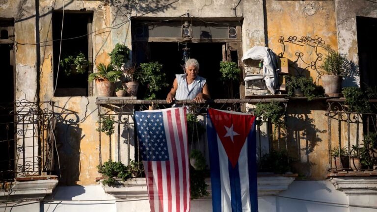 FILE-Javier-Yanez-stands-on-his-balcony-where-he-hung-a-U-S-and-Cuban-flag-in-Old-Havana-Cuba-Friday.jpeg