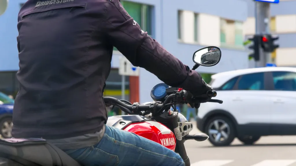 an-der-ampel-der-motorradfahrer-steht-an-der-roten-ampel-salzburg-salzburg-oesterreich-at-the-traffi.webp