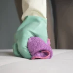 cleaning-a-mattress-with-a-cloth-and-rubber-gloves-in-a-bedroom-a-person-cleans-a-mattress-using-a-c.webp
