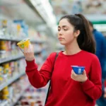 eine-junge-frau-vergleicht-joghurt-symbolbild-bei-einer-gehaltserhoehung-steigt-ihr-nettoeinkommen-n.webp