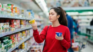 eine-junge-frau-vergleicht-joghurt-symbolbild-bei-einer-gehaltserhoehung-steigt-ihr-nettoeinkommen-n.webp