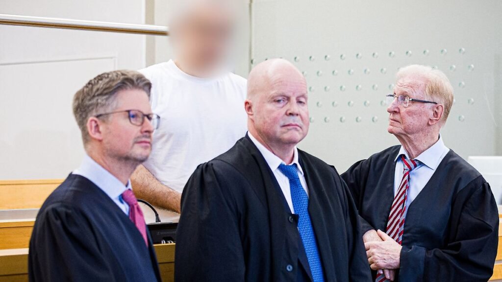 Der-angeklagte-Arzt-hinten-steht-hinter-seinen-Verteidigern-Die-Staatsanwaltschaft-wirft-dem-Angekla.jpeg