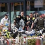 Einsatzkraefte-stehen-vor-einem-Supermarkt-neben-einer-verletzten-Person-auf-einer-Trage-In-dem-Supe.jpeg
