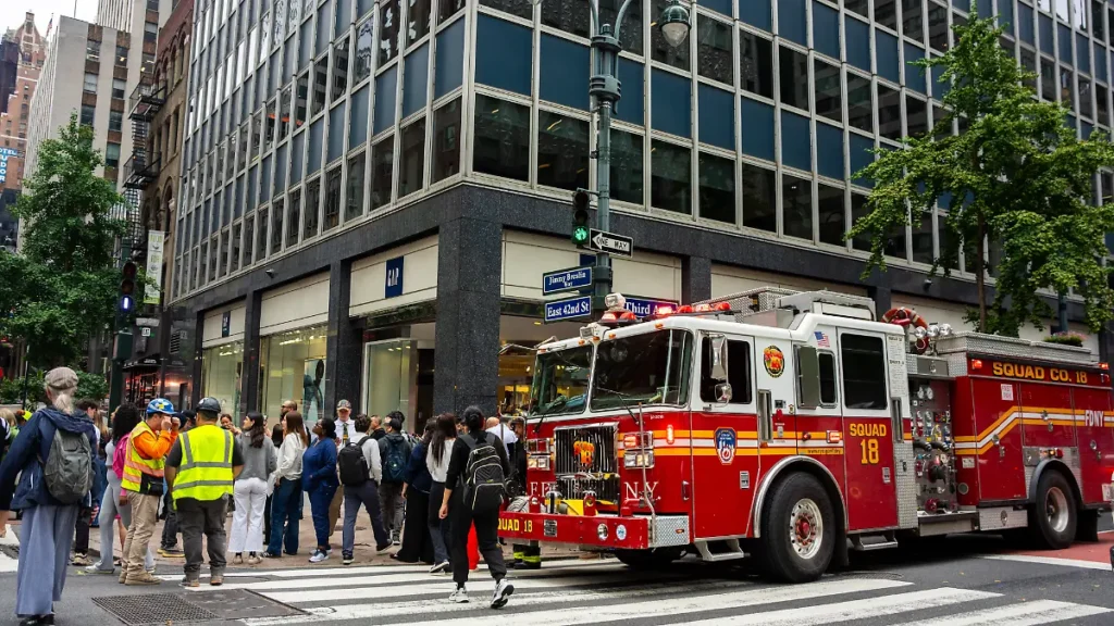 an-der-kreuzung-der-3rd-avenue-und-der-east-42nd-street-steht-ein-feuerwehrauto-nachdem-gebaeude-in.webp
